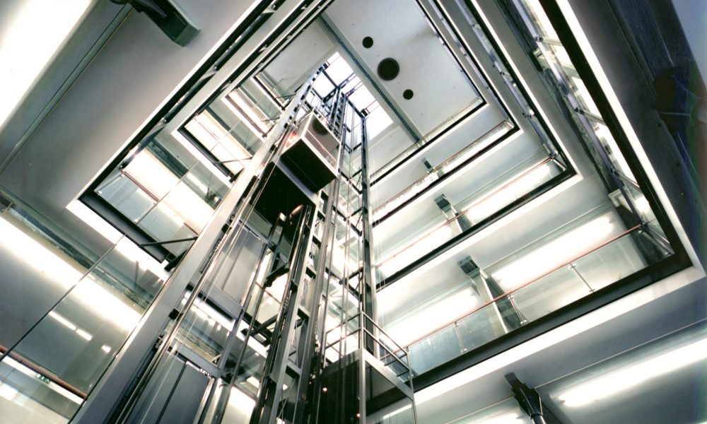 Innen Foyer Lünserseefabrik in Bürs, moderne Empfangshalle Blick in die OG mit Glasbrüstungena