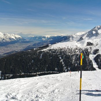 Paar genießt beim Skifahren Blick auf Innsbrucker Bergwelt